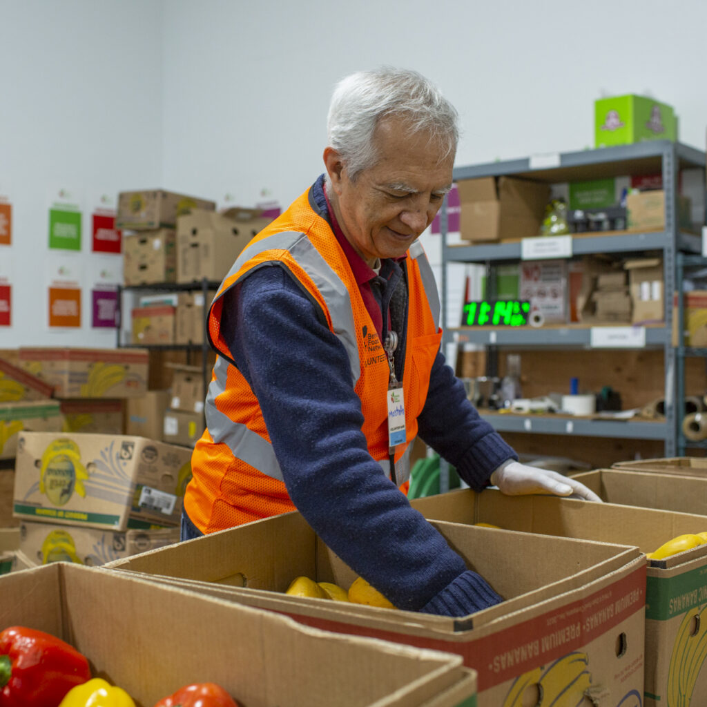 A BFN volunteer sorting produce into boxes in the warehouse